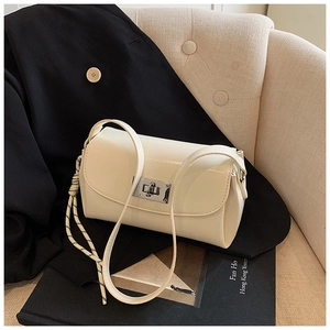 Détail du sac crème avec fermoir rotatif argenté et décoration en cordelette tressée