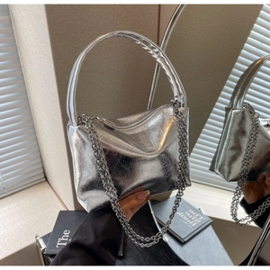 Detailed mirror shot of silver metallic pillow bag with chain and pleated texture