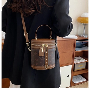 Détail d'un sac seau cylindrique marron avec imprimés dessins animés sur un mannequin