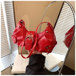 Macro detail of red Y2K hobo bag with silver studs and polished faux leather finish