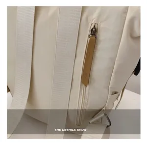 Detalle de la parte trasera de una mochila blanco roto con cremallera lateral y correas gruesas