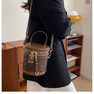 Vue détaillée du mini sac seau marron avec motifs de chiens et ferrures en métal doré