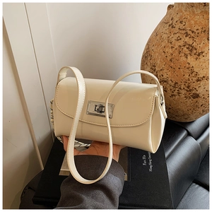 Gros plan du sac bandoulière blanc crème avec boucle métallique rotative argentée