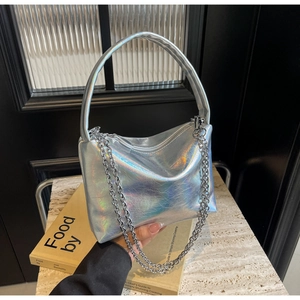 Macro shot of silver holographic leather texture and metal chain on a crossbody bag