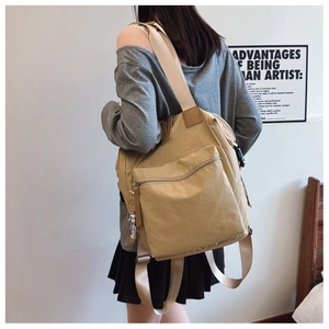 Vista trasera de una mochila caqui de gran capacidad con correas de nailon y colgante