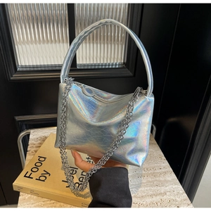 Detailed view of silver holographic pillow bag with chain strap and metallic texture
