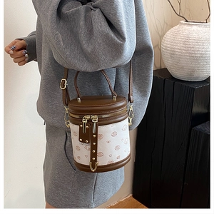 Détails d'un mini sac seau cylindrique avec motifs cœurs et bandoulière réglable