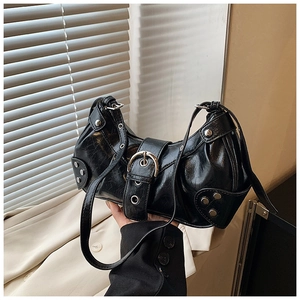 Detail of black faux leather shoulder bag with metallic buckle and silver rivets