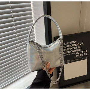 Detail of silver metallic underarm bag featuring sleek chain and holographic texture