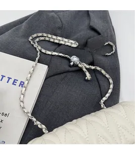 Detail of adjustable silver ball slider on white quilted chain shoulder strap bag