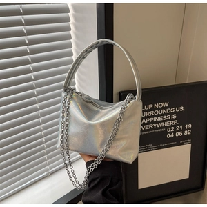 Detail of silver laser textured handbag showing wrinkled leather and metallic chain strap