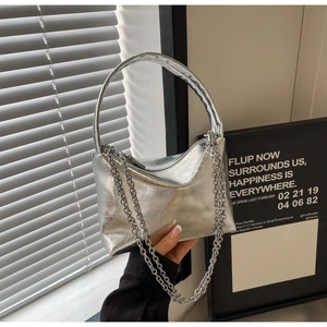 Close-up of the silver metallic chain strap and textured pleats on this shoulder bag