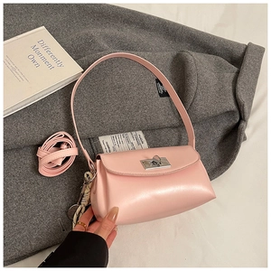 Détail d'un sac à main rose avec fermoir argenté et foulard décoratif sur manteau
