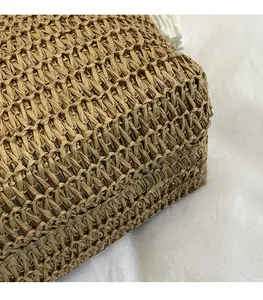 Detailed macro view of high-quality hand-woven straw texture in a warm beige summer tote bag