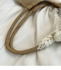 Detailed macro of woven straw handle with elegant white lace trim on a beach tote bag