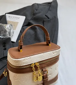 Detail of lychee textured leather box bag with floral embossing and gold hardware