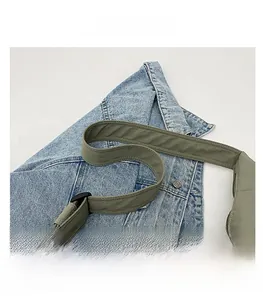 Detail of the wide reinforced shoulder strap on olive green nylon crossbody bag