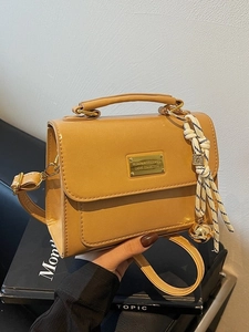 Chic yellow PU leather crossbody bag with top handle and decorative tassel detail