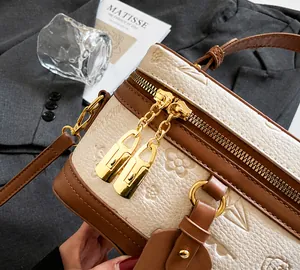 Detail of lychee leather bucket bag with 3D floral embossing and gold hardware lock