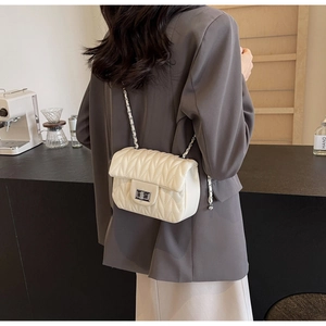 Crossbody view of an off-white V-quilted small square bag with silver chain and metal lock