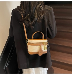 Detail of vintage box-shaped bucket bag with floral embossing and gold-tone zippers