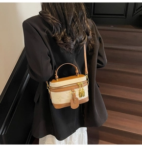 Detailed back view of a woman wearing a vintage white and brown embossed box crossbody bag