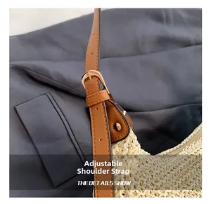 Detail of adjustable brown leather shoulder strap with golden metal buckle on straw tote bag