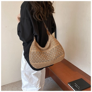 Close-up of bohemian woven straw bag texture and deep brown leather shoulder strap