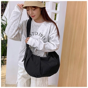 Black pleated crossbody dumpling bag shown on model for daily commute and casual style
