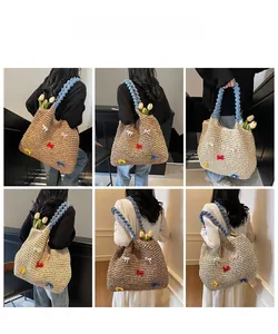 Detail of handwoven straw tote featuring colorful bows and blue plush handle accents