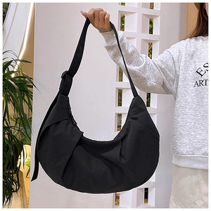 Detail of a black crescent shoulder bag featuring waterproof crinkled nylon fabric
