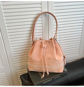 Dettaglio borsa a secchiello rosa con coulisse e motivo intrecciato sul fondo