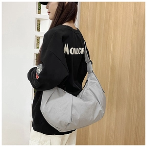 Detail of grey nylon crescent crossbody bag with pleated texture and adjustable strap