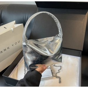 Detail of silver metallic hobo bag with pleated texture and chain strap in luxury gift box