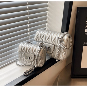Detail of silver quilted handbags with chain straps and metallic turn-lock closures