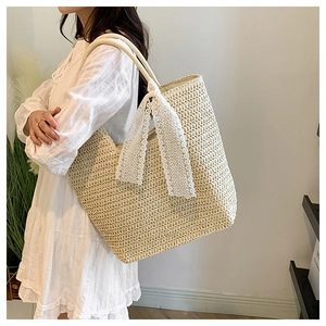 Close-up of beige woven tote bag featuring an elegant white lace bow and detailed texture