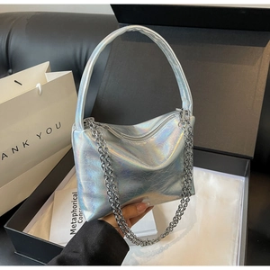 Detailed shot of holographic silver bucket bag with chain strap in a premium gift box