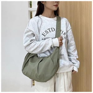 Detail of olive green crescent crossbody bag with pleated base and wide strap