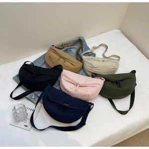 Detail showing various colors of nylon dumpling bags with adjustable straps and zippers