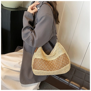 Detail of woven straw shoulder bag with dark brown mesh overlay and leather strap