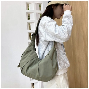 Detail of olive green pleated crossbody dumpling bag with wide adjustable shoulder strap