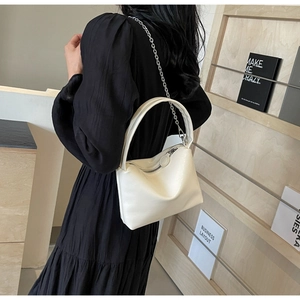 Close-up of cream white bucket bag with silver chain strap and smooth leather texture