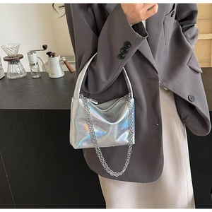 Detail of silver holographic shoulder bag with metallic chain and pleated texture
