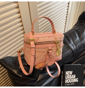Pink box-shaped bag with embossed butterfly floral textures and golden hardware