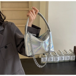 Close-up of silver holographic bucket bag with metallic chain and handle detail