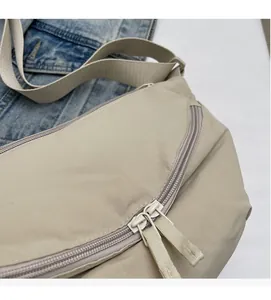 Detailed view of cream nylon dumpling bag with tear-resistant grid texture and metal zipper