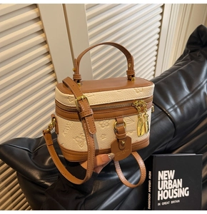 Detail of box bag featuring embossed floral patterns, gold hardware, and top handle