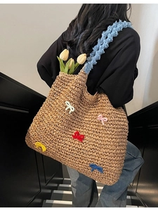 Straw tote bag with colorful bows and blue ruffled straps for beach vacations