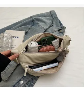 Interior view showing spacious compartments of a beige nylon crossbody sling bag