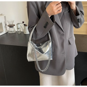 Detailed view of silver metallic textured bucket bag with decorative silver chain strap
